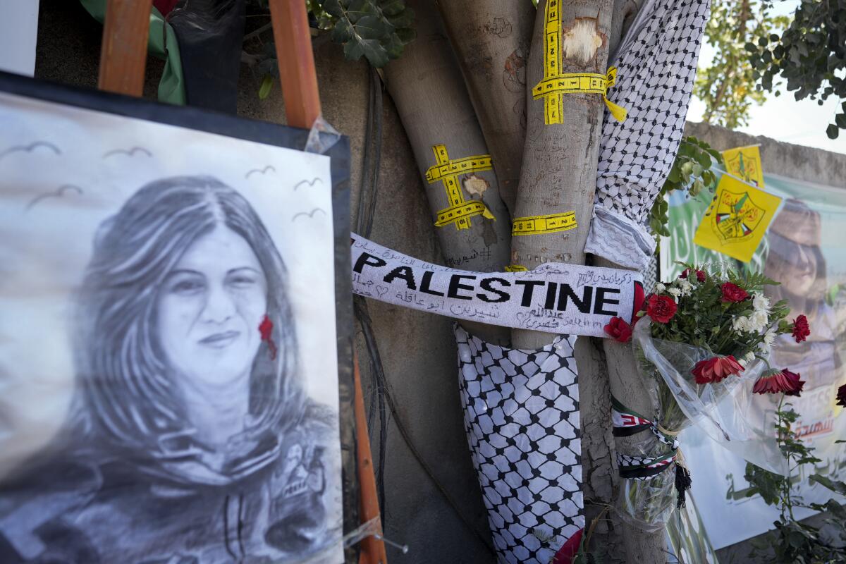 FILE - Yellow tape marks bullet holes on a tree and a portrait and flowers create a makeshift memorial, at the site where Palestinian-American Al-Jazeera journalist Shireen Abu Akleh was shot and killed in the West Bank city of Jenin, May 19, 2022. The Israeli military acknowledged for the first time on Monday, Sept. 5, 2022, that one of its soldiers likely killed veteran Al Jazeera journalist Shireen Abu Akleh in May, saying its own investigation shows she was shot by mistake and that no one will face punishment. (AP Photo/Majdi Mohammed, File)