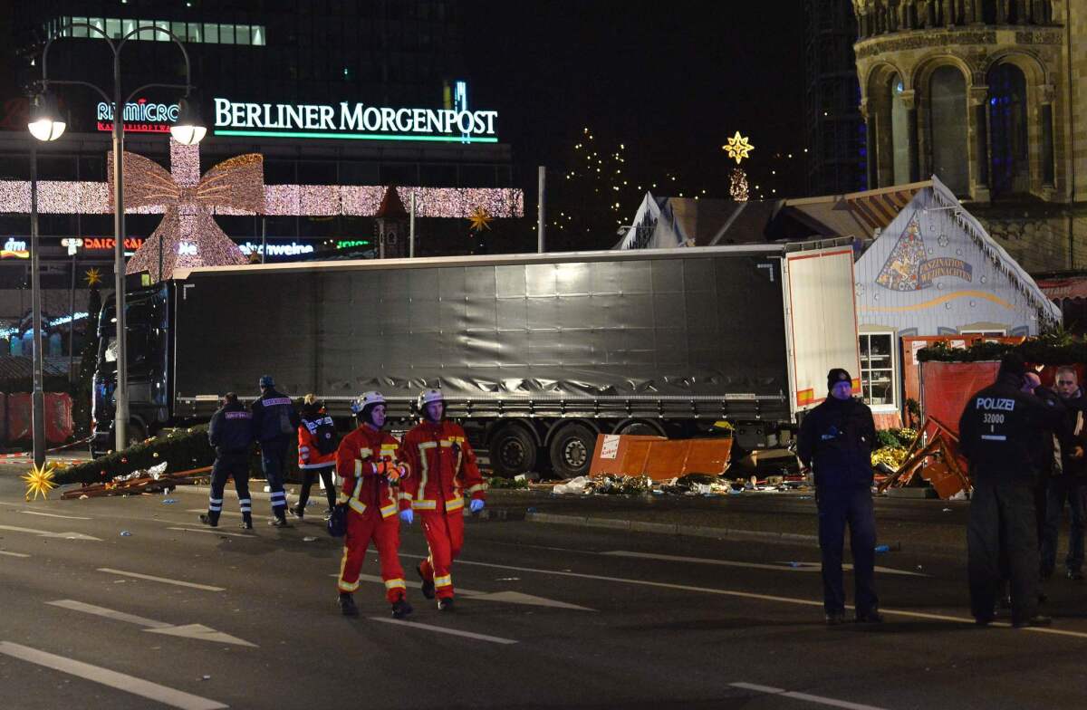 Firefighters pass by the truck that crashed into a Christmas market in Berlin on Dec. 19, 2016.