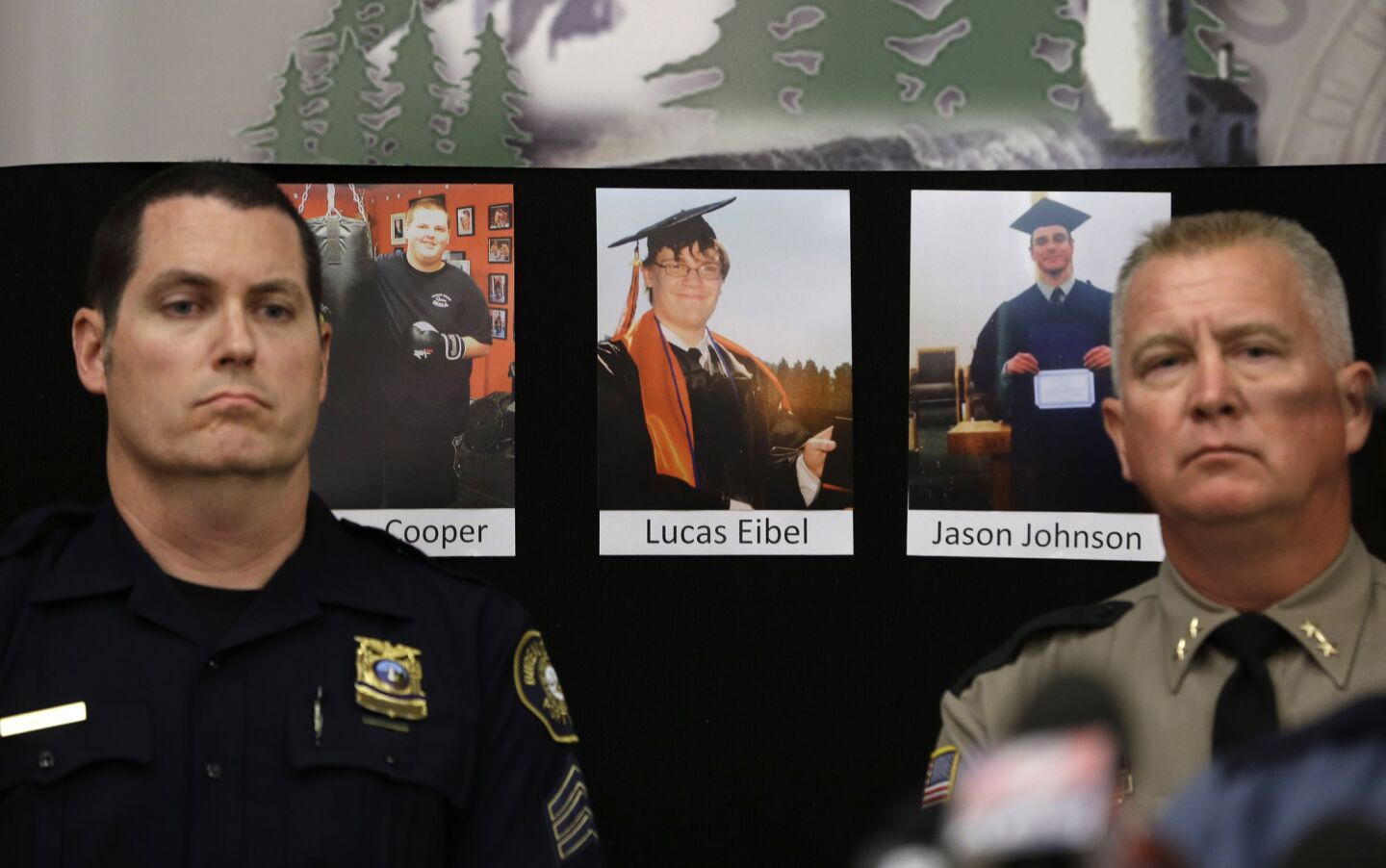 Portland Police Sgt. Peter Simpson, left, and Douglas County Sheriff John Hanlin stand in front of photos of three of the victims of the Umpqua Community College shooting. In the photos, from left, are Quinn Cooper, 18, Lucas Eibel, 18, and Jason Johnson, 33.