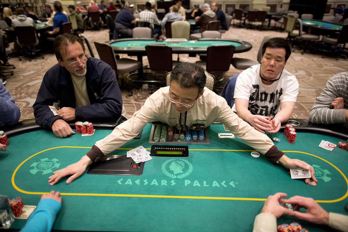 ARCHIVO - En esta fotografía de archivo del 27 de febrero de 2013, el dealer Han Kim, al centro, reúne fichas tras repartir una mano de Texas Hold 'em, una versión de póquer, en el casino Caesar's Palace en Las Vegas. Una caída en el número de personas que juegan bacará y un enero con más eventos hace un año contribuyeron a un descenso de 2,9% en las ganancias de casinos de Nevada el mes pasado, de acuerdo con información de las autoridades divulgada el viernes 26 de febrero de 2016. (Foto AP/Julie Jacobson, archivo)
