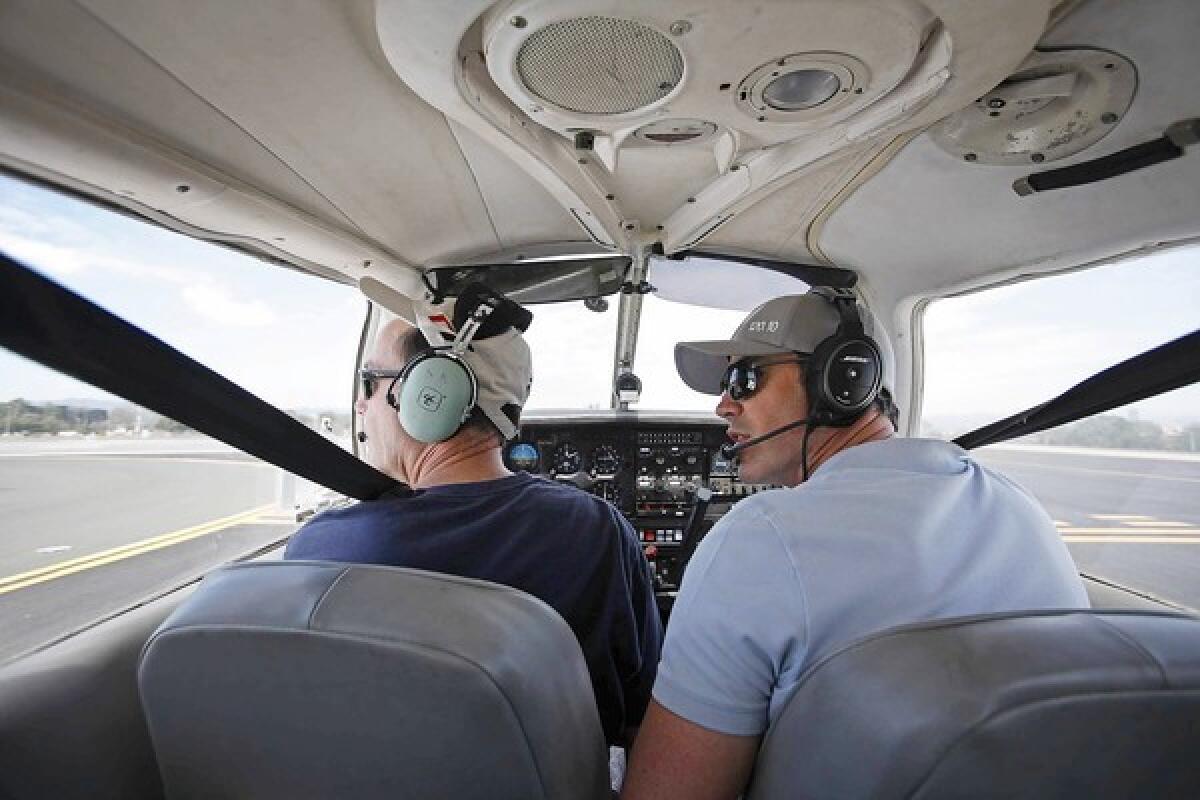 Flight instructor Rob Williams, right, and student Mike Pinson check the wind direction before taking off from Santa Monica Airport.