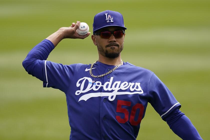 Los Angeles Dodgers right fielder Mookie Betts (50) warms up before a spring training baseball game against the Colorado Rockies Monday, March 15, 2021, in Scottdale, Ariz. (AP Photo/Ashley Landis)