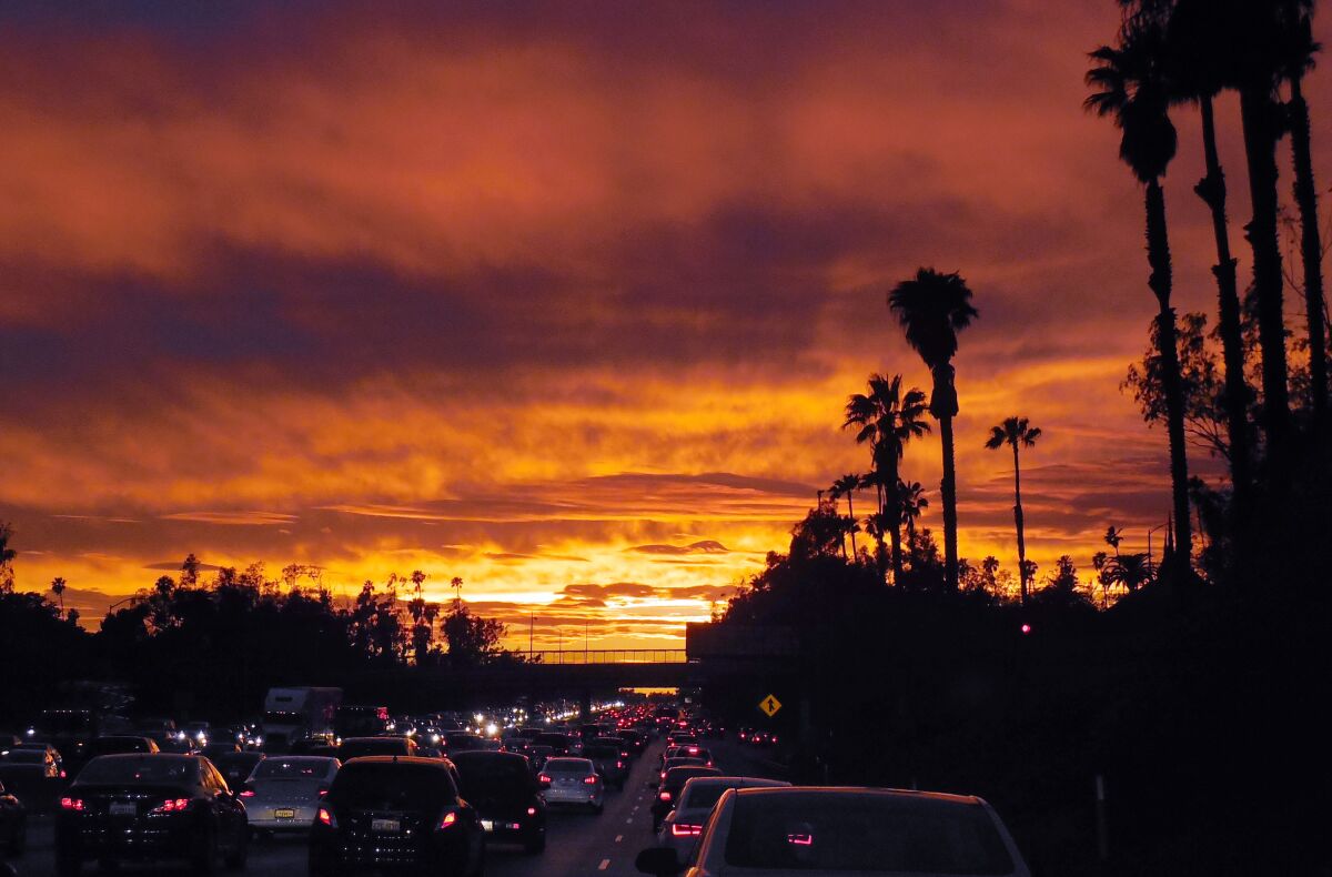 Cars stuck in traffic on a freeway at sunset