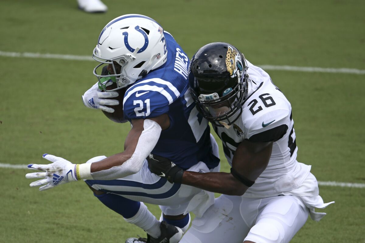 Indianapolis Colts running back Nyheim Hines (21) scores a touchdown on a 12-yard run as he is brought down by Jacksonville Jaguars safety Jarrod Wilson (26) during the first half of an NFL football game, Sunday, Sept. 13, 2020, in Jacksonville, Fla. (AP Photo/Stephen B. Morton)