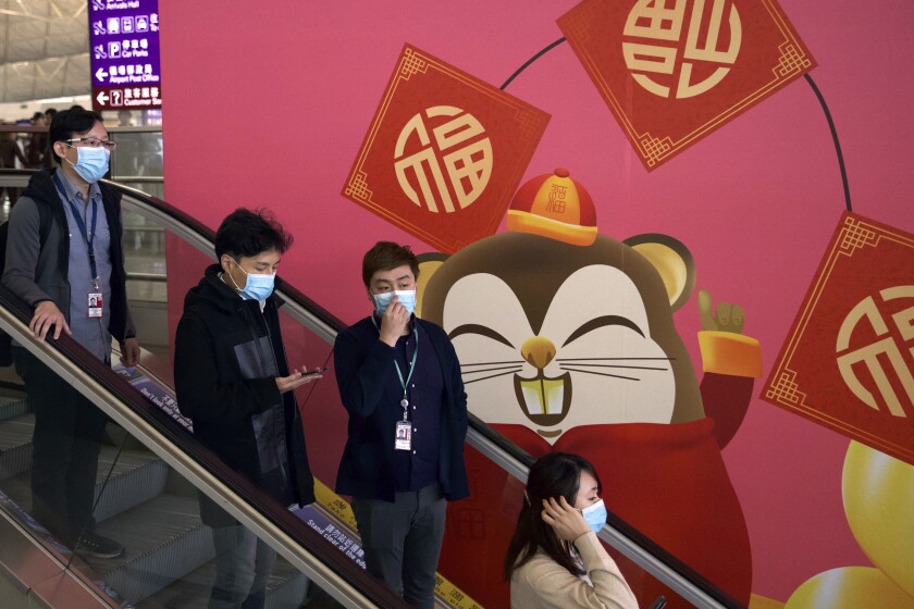 People wear face masks Jan. 21 at Hong Kong International Airport. Millions of people will travel this week for the Lunar New Year.