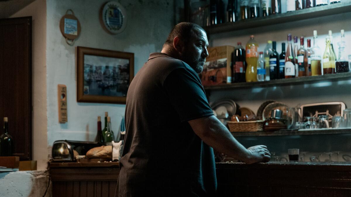 A man stands alone at a kitchen bar.