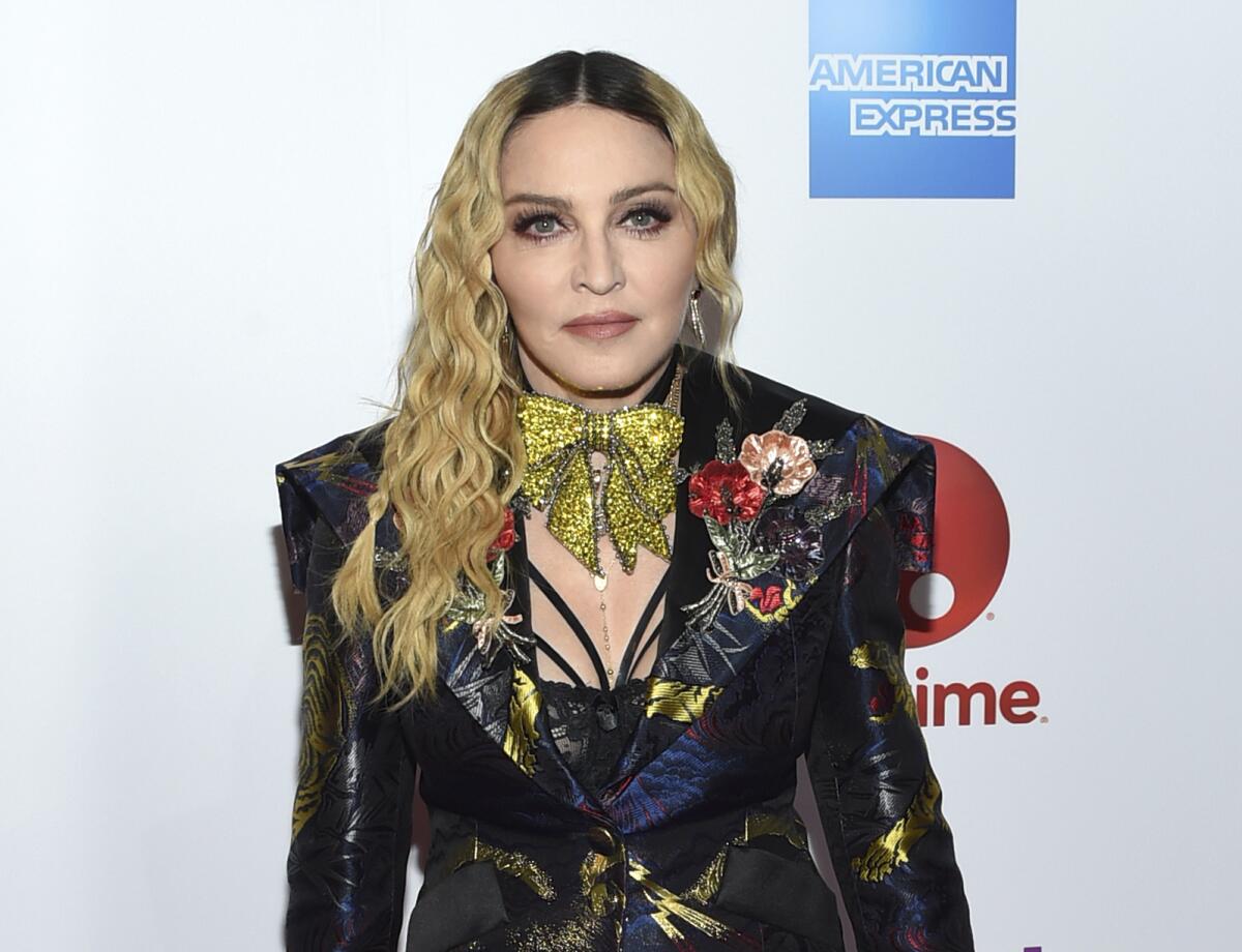 Madonna in a black blazer with metallic detailing posing at a red carpet