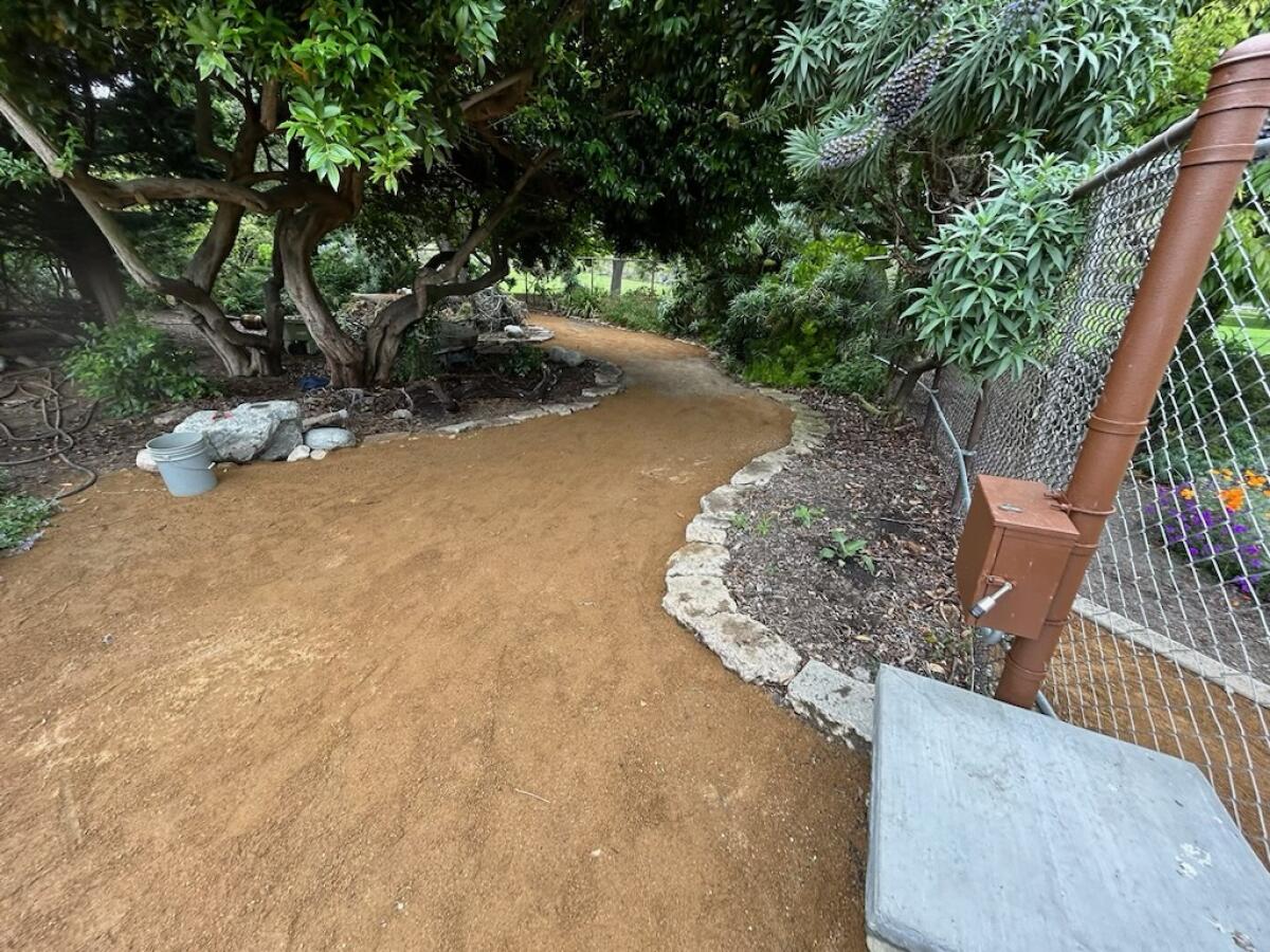 Fresh gravel was laid on the paths winding through the Secret Garden at Huntington Central Park Wednesday, May 24.