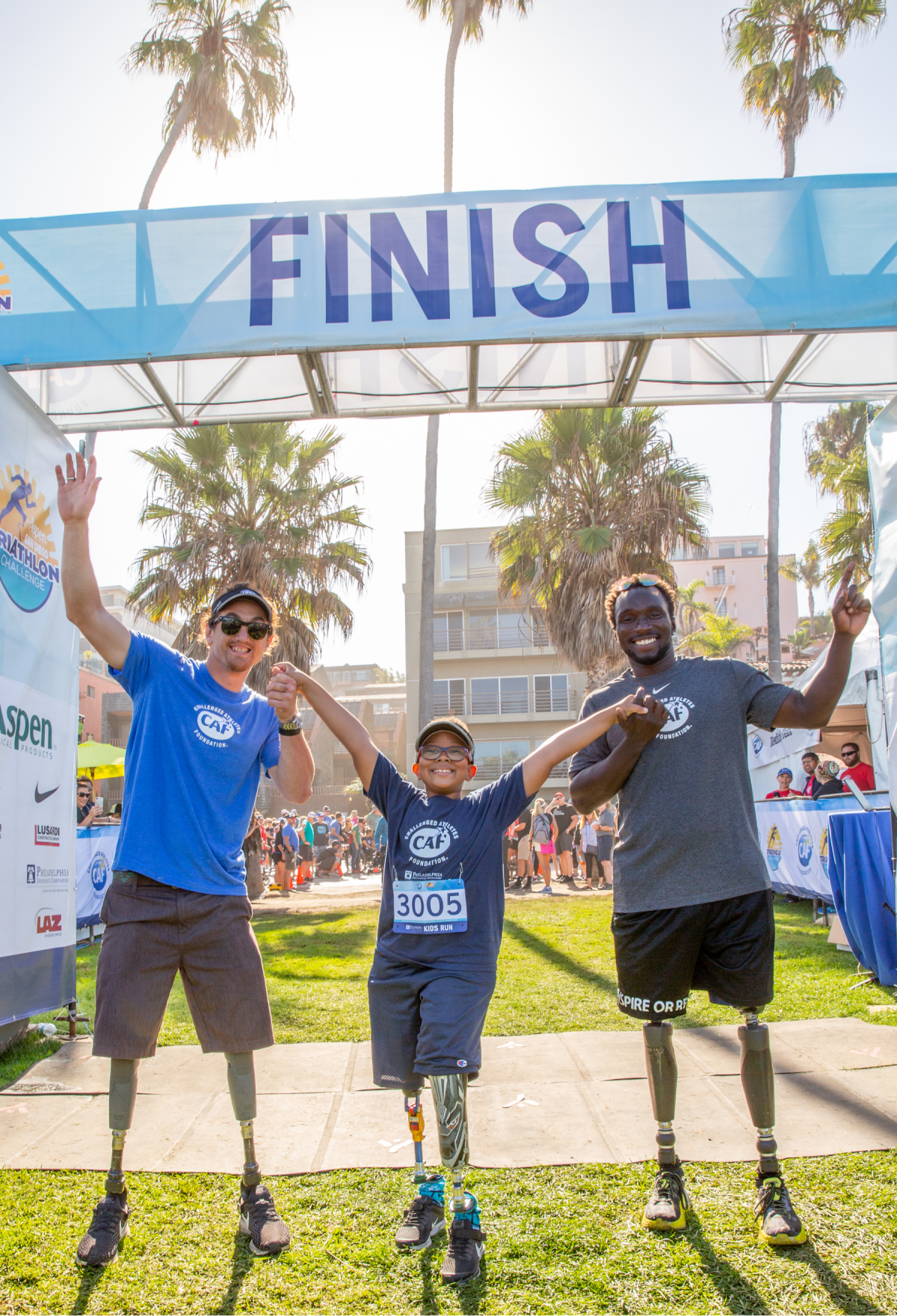 Double-amputees Rudy Garcia-Tolson, left, Logan Seitz and Roderick Sewell cross the race finish line together.