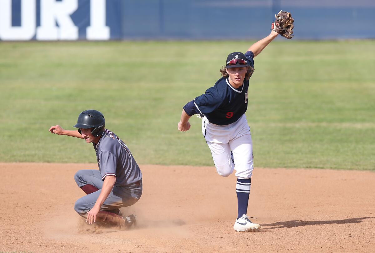 Newport Harbor's John Olmstead, right, turns a double play as Laguna Beach's Will Potratz slides into second during a Wave League game in Newport Beach on March 29.