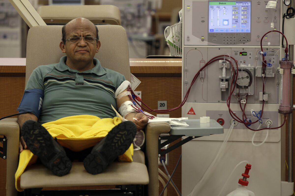 Giraldo Garcia, with feet up and eyes closed, receives dialysis treatment.