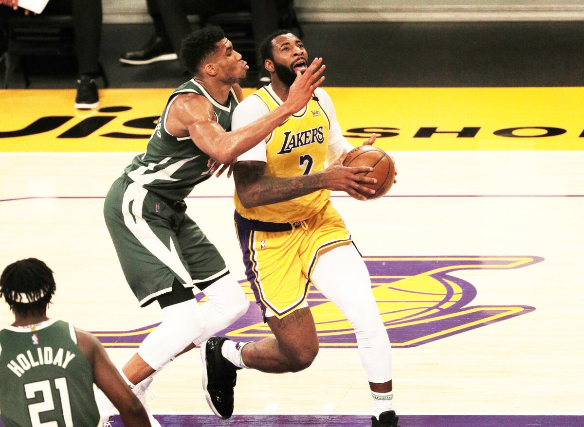 Lakers Andre Drummond drives to the basket against Milwaukee Bucks forward Giannis Antetokounmpo.