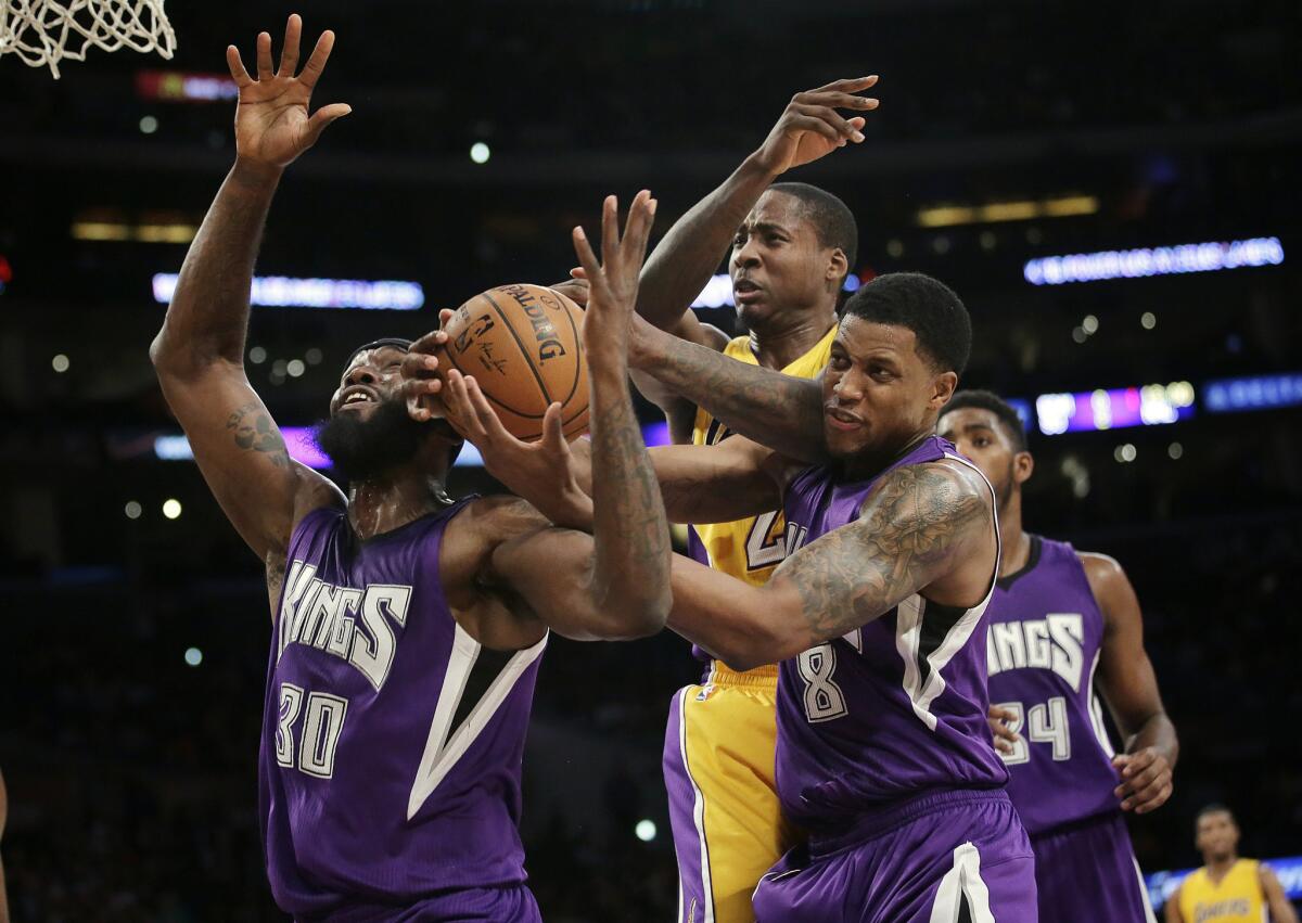 Sacramento's Reggie Evans, left, and Rudy Gay, right, tangle with Ed Davis for a rebound during the first half of a game at Staples Center.