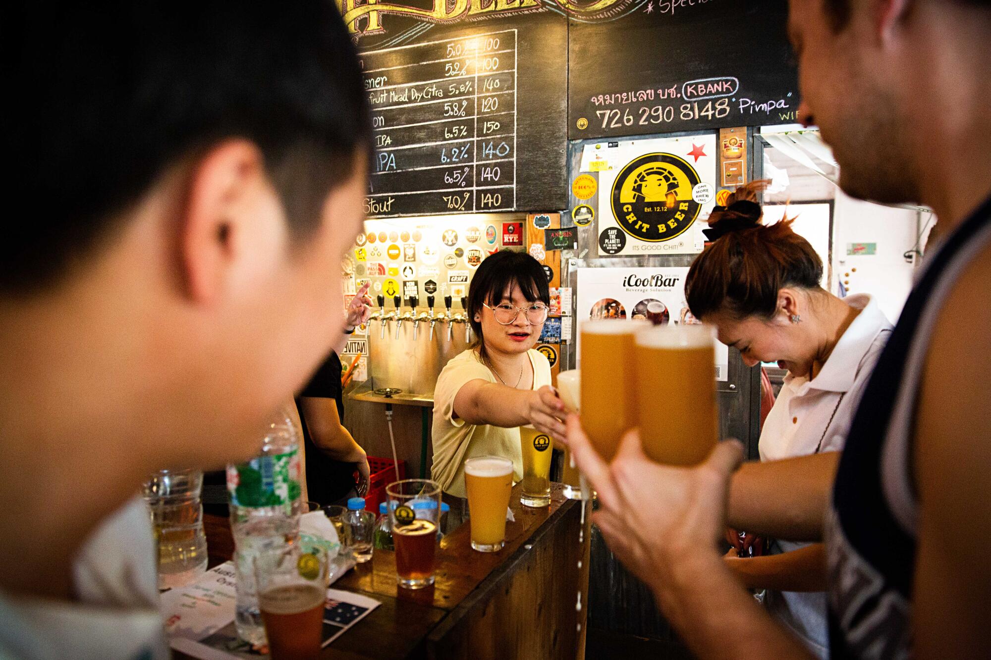 A bartender serves patrons at Chit Beer in Thailand