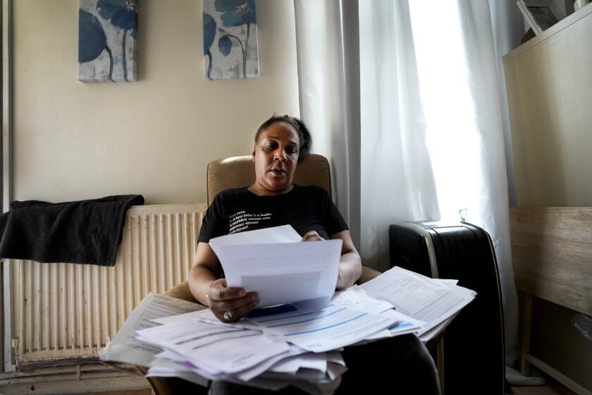 Jennifer Jones sorts her bills at her small flat in London, Thursday, Aug. 25, 2022. Like millions of people, Jones, 54, is struggling to cope as energy and food prices skyrocket during Britain's worst cost-of-living crisis in a generation. The former school supervisor has health problems and relies on government benefits to get by, but her welfare payments are nowhere near enough to cover her sharply rising bills. (AP Photo/Frank Augstein)