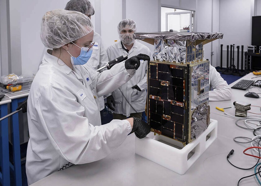 Rebecca Rogers, systems engineer, left, takes dimension measurements of the CAPSTONE spacecraft in April 2022, at Tyvak Nano-Satellite Systems, Inc., in Irvine, Calif. NASA said Tuesday, July 5, that it has lost contact with a $32.7 million spacecraft headed to moon to test out a lopsided lunar orbit, but agency engineers are hopeful they can fix the problem. (Dominic Hart/NASA via AP)