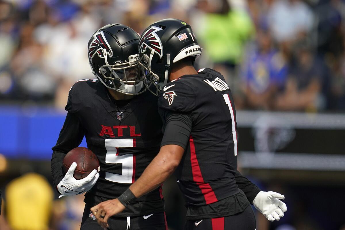 Atlanta Falcons wide receiver Drake London celebrates with quarterback Marcus Mariota.