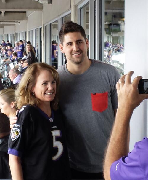 Injured Ravens tight end Dennis Pitta poses for pictures with fans in owner Steve Bisciotti's suite before the game against the Houston Texans.