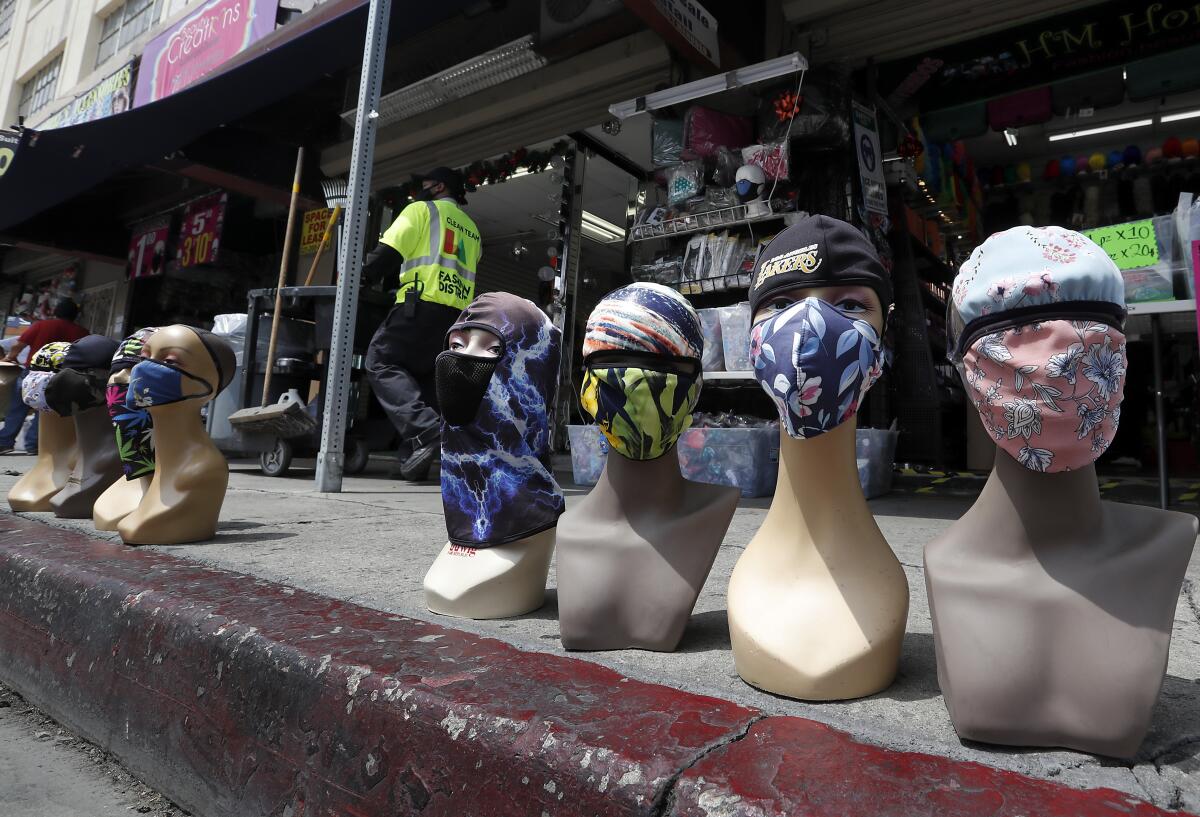 Mannequins wearing protective masks line the sidewalk last week in Los Angeles' Garment district.