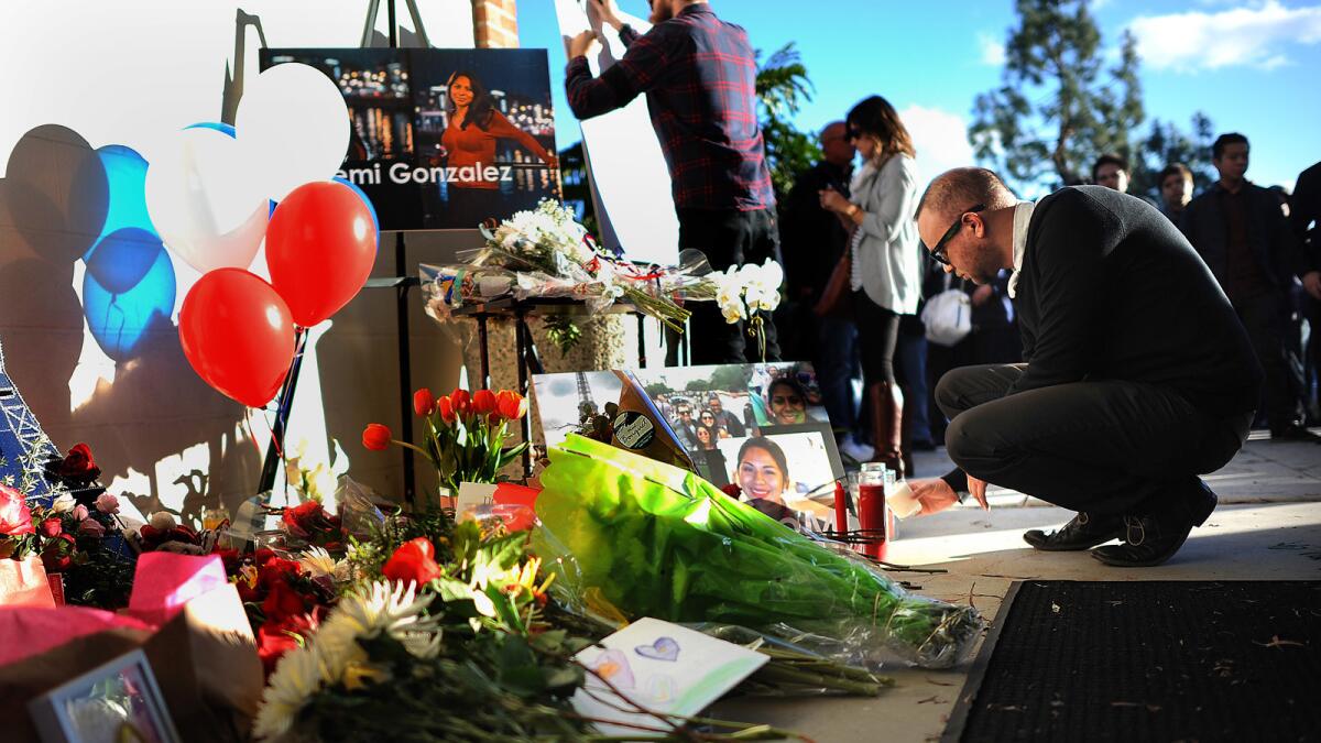 Flowers and photos are left at a makeshift memorial for Nohemi Gonzalez outside of the design building at Cal State Long Beach.