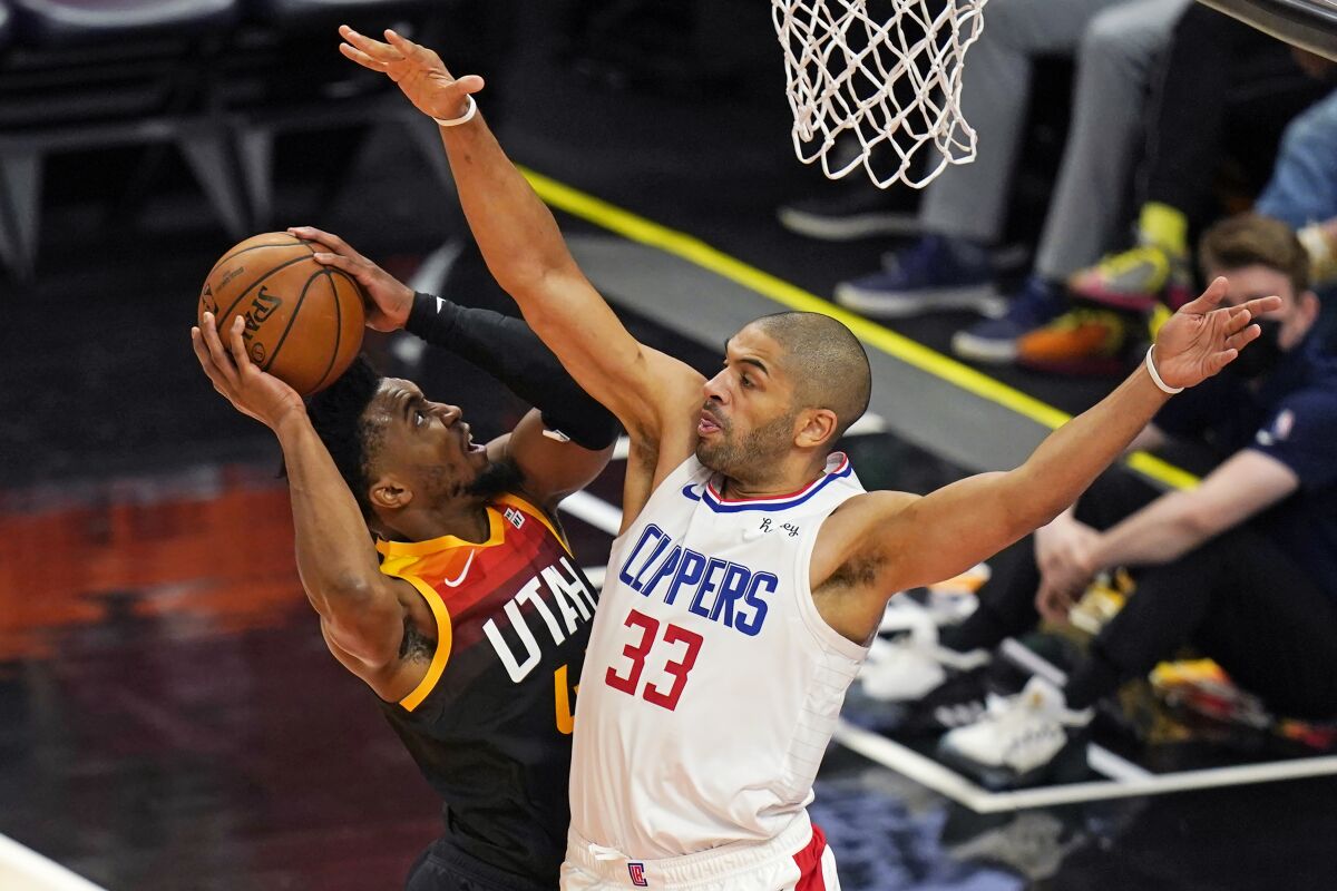 Clippers forward Nicolas Batum #33 defends as Jazz guard Donovan Mitchell attempts a layup.