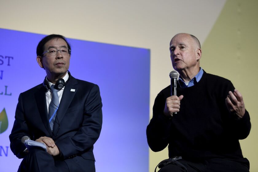 Seoul Mayor Park Won-soon listens to Gov. Jerry Brown during a working session for "Action Day" at the U.N. conference on climate change Saturday in France.
