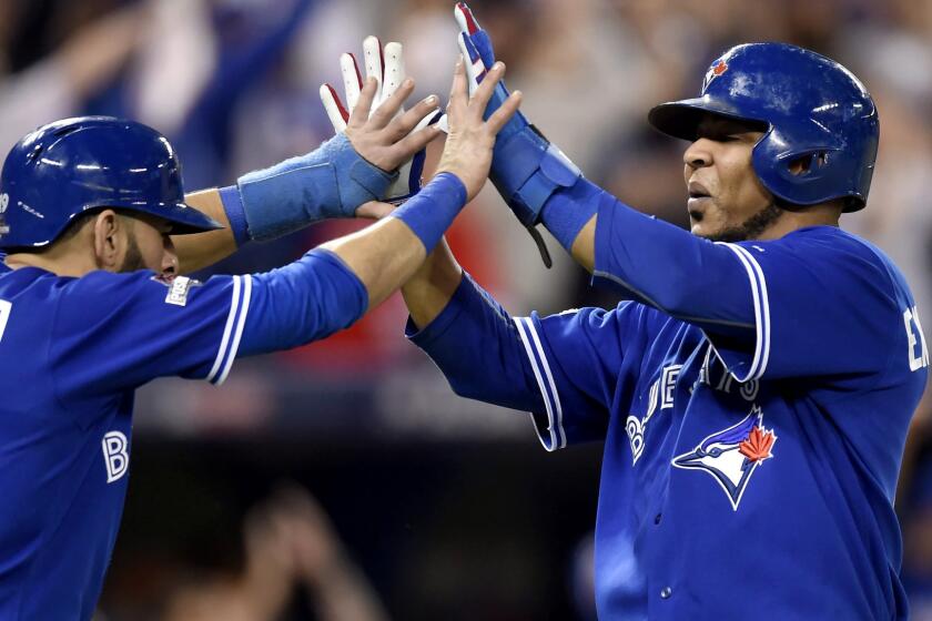 Blue Jays right fielder Jose Bautista, left, and designated hitter Edwin Encarnacion celebrate after scoring on a three-run double by Troy Tulowitzki in the sixth inning in Game 5 of the ALCS.