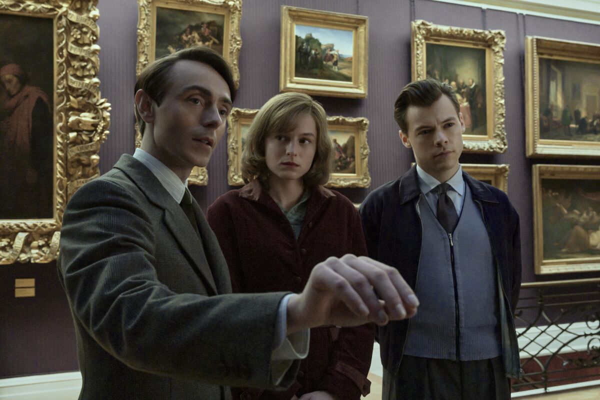 Two men and a woman admire paintings in a museum in "My Policeman."