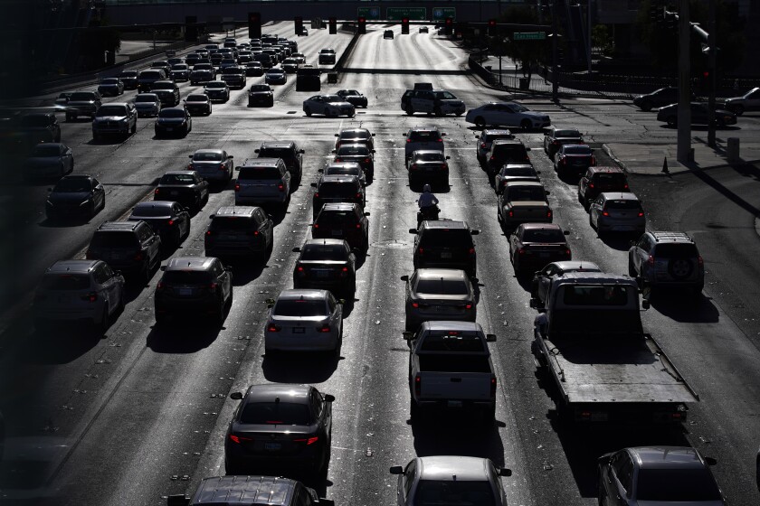 FILE - In this April 22, 2021 file photo, cars wait at a red light during rush hour at the Las Vegas Strip, in Las Vegas. Two organizations that influence many Americans’ automobile buying decisions will begin rating vehicles on how well they track behavior of motorists who use partially automated driver-assist systems. Consumer Reports and the Insurance Institute for Highway Safety say the ratings will factor into scores for new models starting this year. The new ratings, announced Thursday, Jan. 20, 2022 come as the auto industry struggles with how to make sure drivers stay alert as the systems take on more driving functions. (AP Photo/John Locher, File)