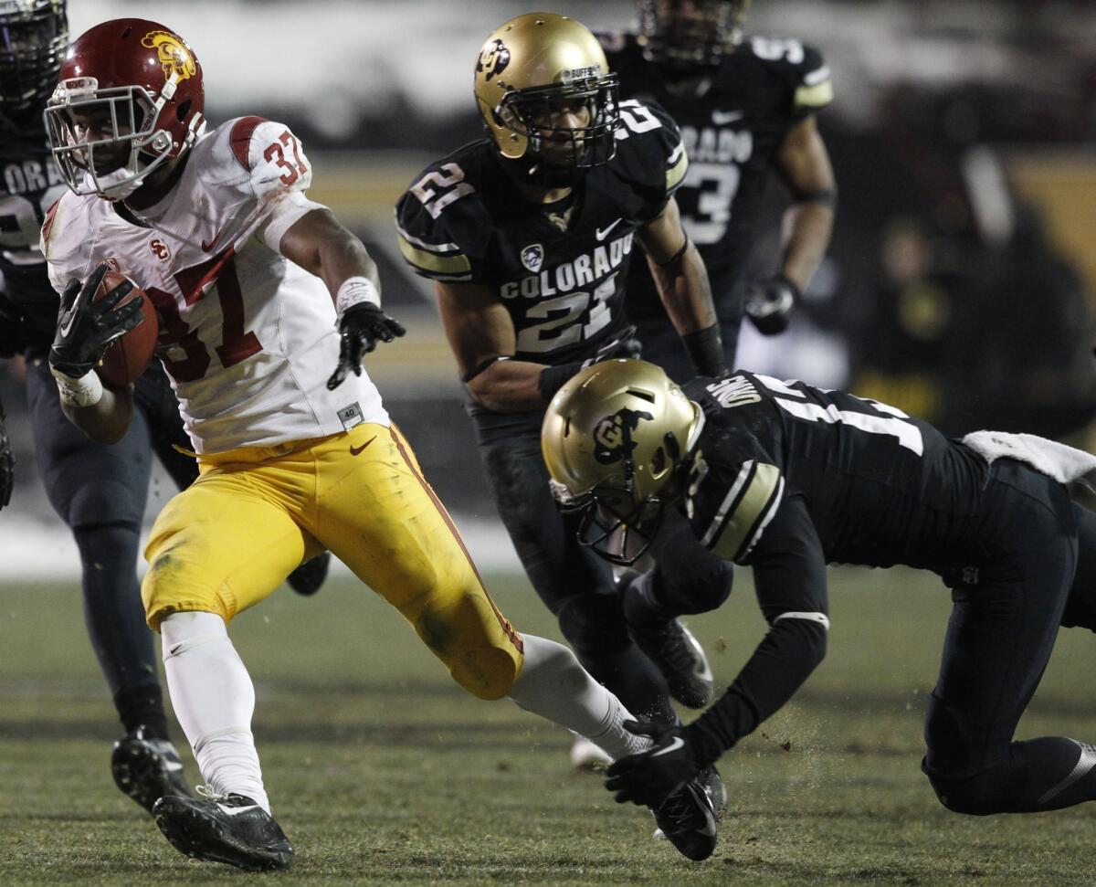 USC tailback Javorius Allen, left, runs for a long gain past Colorado defensive backs Jered Bell, center, and Parker Orms in the fourth quarter of the Trojan's 47-29 victory Saturday in Boulder.