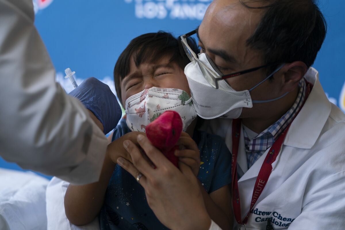 Callum Diaz-Cheng, 3, reacts in the arms of his father, Dr. Andrew Cheng, after receiving the Pfizer COVID-19 vaccine.