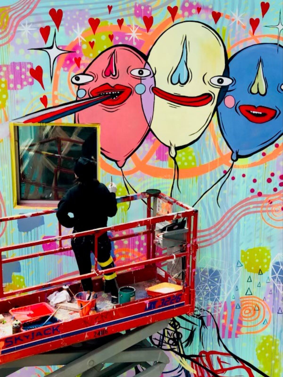 Paola Villaseñor, known as the artist Panca, working on a colorful mural