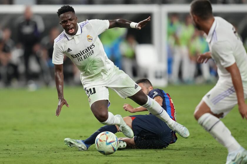 Real Madrid's Vinicius Paixao gets tackled during the first half of a friendly soccer match against Barcelona, Saturday, July 23, 2022, in Las Vegas. (AP Photo/John Locher)