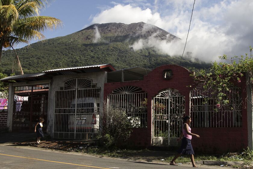 En esta imagen del lunes 28 de noviembre de 2022, personas caminan en Chinameca, cerca del volcán Chaparrastique, en El Salvador. (AP Foto/Salvador Melendez)