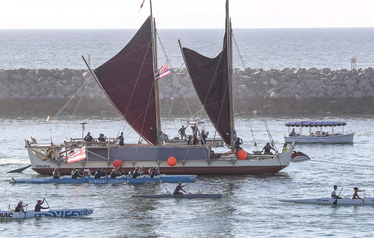 The Hawaiian canoe Hokule‘a is escorted by outrigger club boats during a traditional arrival ceremony in Newport Harbor.