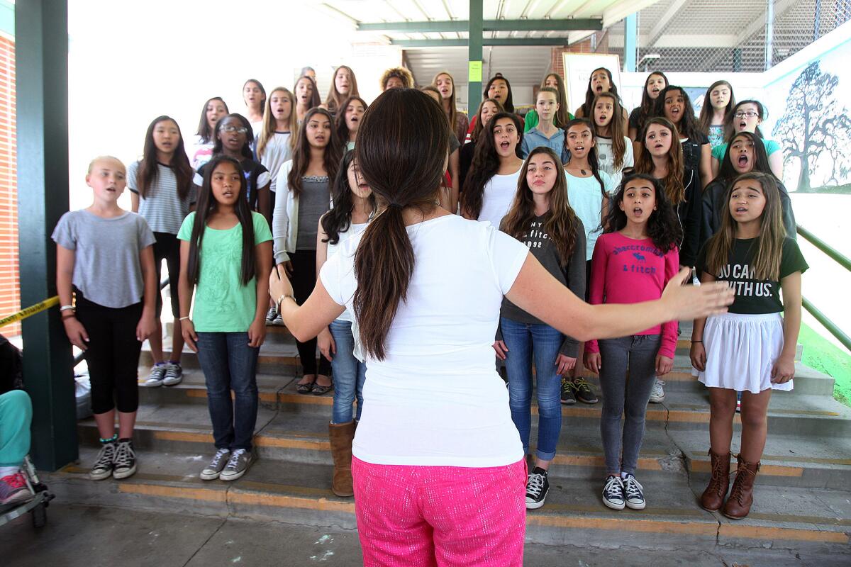 John Muir Middle School choir teacher Lydia Lee directs the choir in singing "God Bless America" in this file photo taken on Thursday, April 17, 2014.