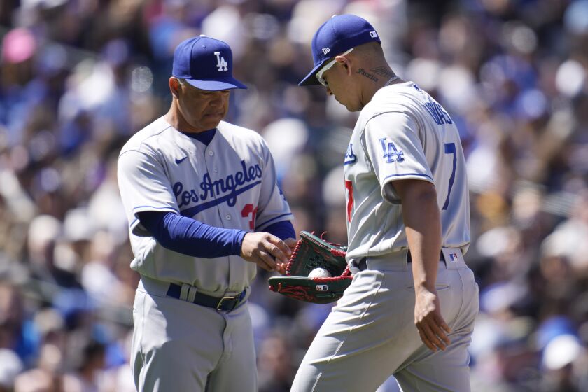 Los Angeles Dodgers manager Dave Roberts, left, takes the ball from starting pitcher Julio Urias.