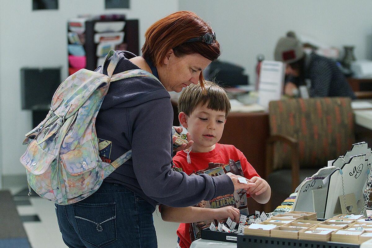 Melanie Paige, of Sunland, with her son Marcus, 6, shop for crystal jewelry at the Creative Arts Center 2013 Holiday Arts & Crafts Boutique on Friday, December 6, 2013. All the items are produced by local artists who get an 85% split of the sale if their artwork sells. The other 15% goes to the Burbank Fine Arts Federation.