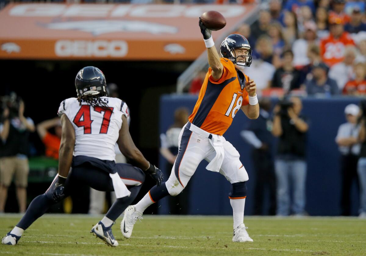 Denver Broncos quarterback Peyton Manning throws as Houston Texans linebacker Quentin Groves defends on Aug. 23.