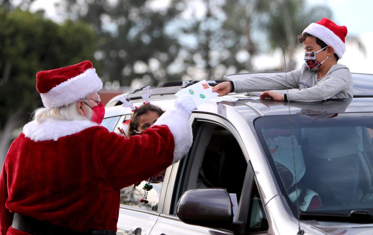 Santa Claus receives a personalized letter from 6-year-old Joey Martinez as his twin sister, Elyse, looks on.