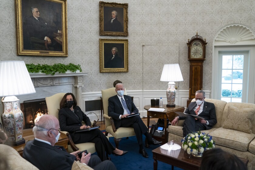 President Biden and Vice President Kamala Harris sitting under an FDR portrait during an Oval Office meeting