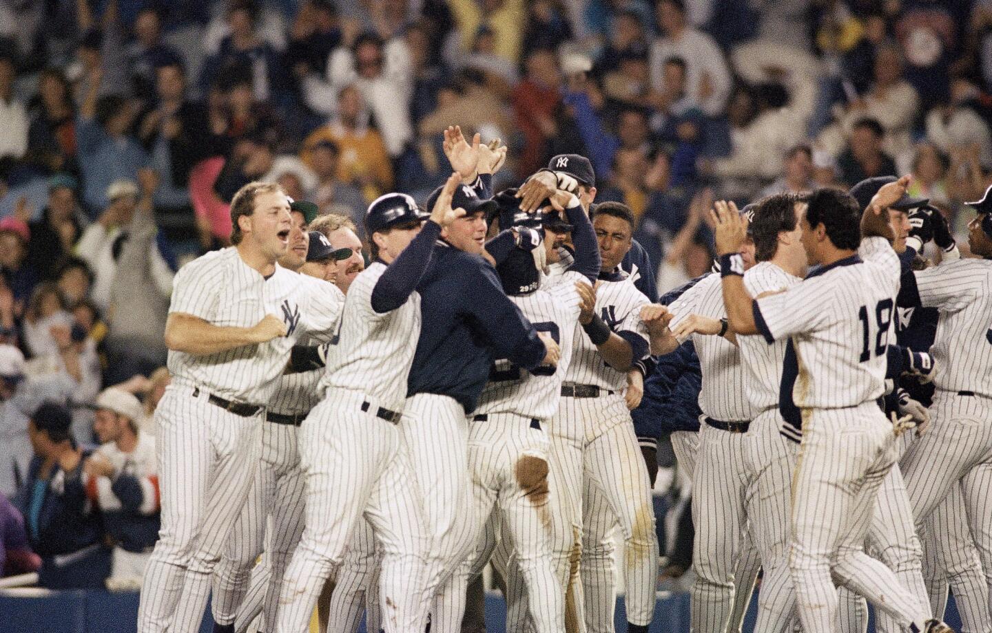 New York Yankees Don Mattingly, second from right, is mobbed by teammates after hitting a two-out, two-RBI single in the bottom of the ninth inning against the Boston Red Sox in New York on Saturday, Sept. 18, 1993. The Yankees won 4-3 when they took advantage of another chance after a fan ran onto the field as an apparent final out was being made. (AP Photo/Mark Lennihan)