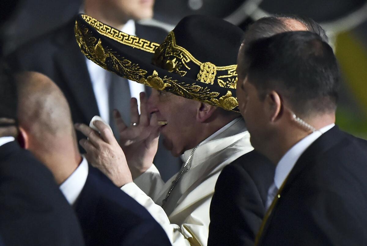 Pope Francis wears a sombrero upon arrival in Mexico City.