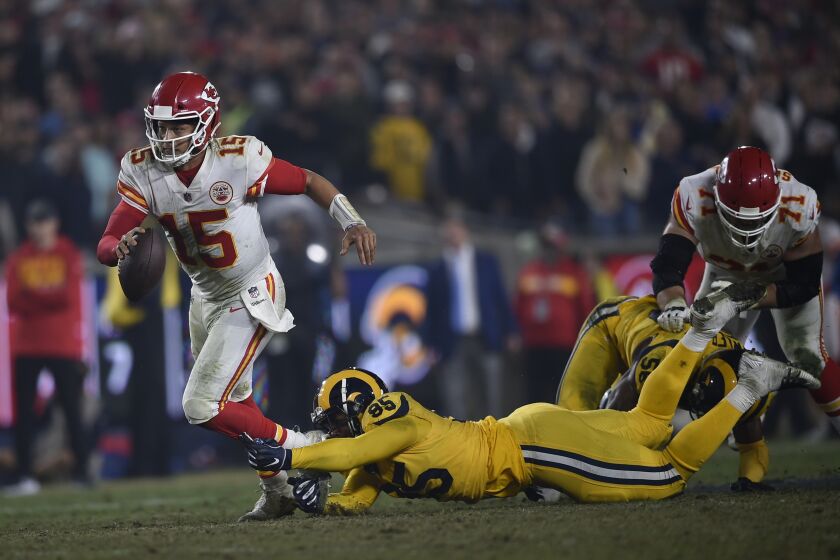 Kansas City Chiefs quarterback Patrick Mahomes (15) tries for extra yardage as he is tripped up by Los Angeles Rams defensive tackle Ethan Westbrooks, right, during the second half of an NFL football game, Monday, Nov. 19, 2018, in Los Angeles. (AP Photo/Kelvin Kuo)