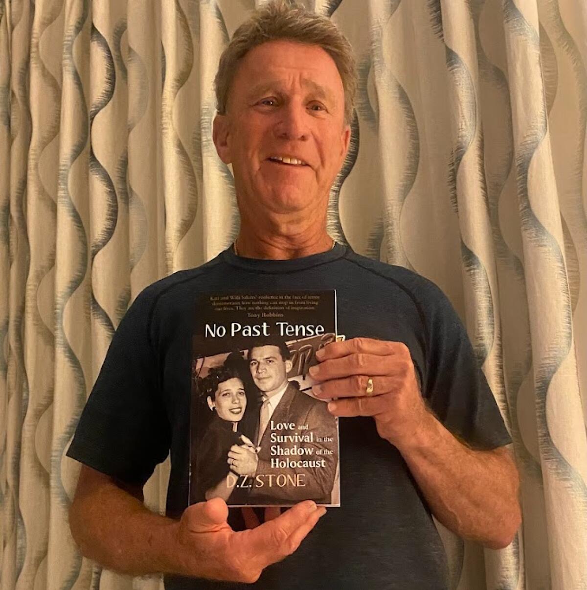 Ron Salcer, a pro hockey agent, holds up a book about his parents, who were Holocaust survivors.