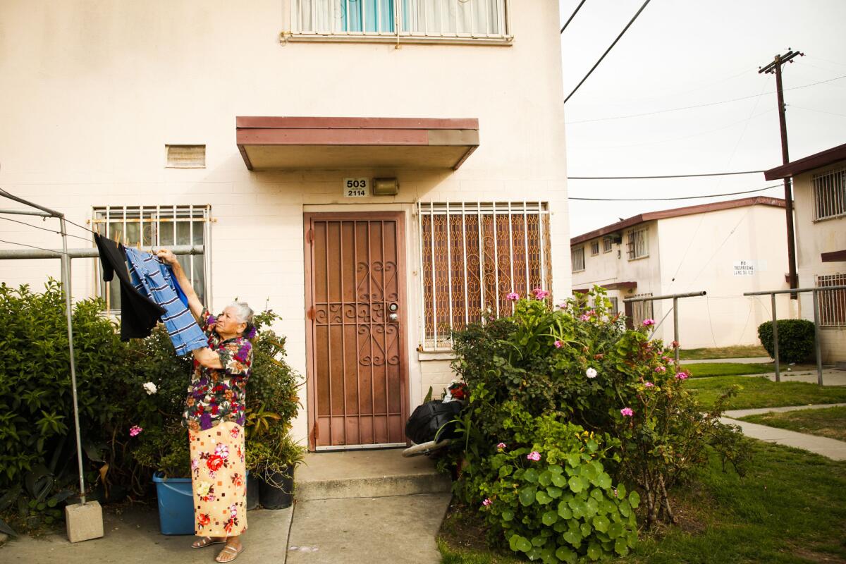 A resident hangs laundry outside of a residence in the Jordan Downs housing project in Watts.