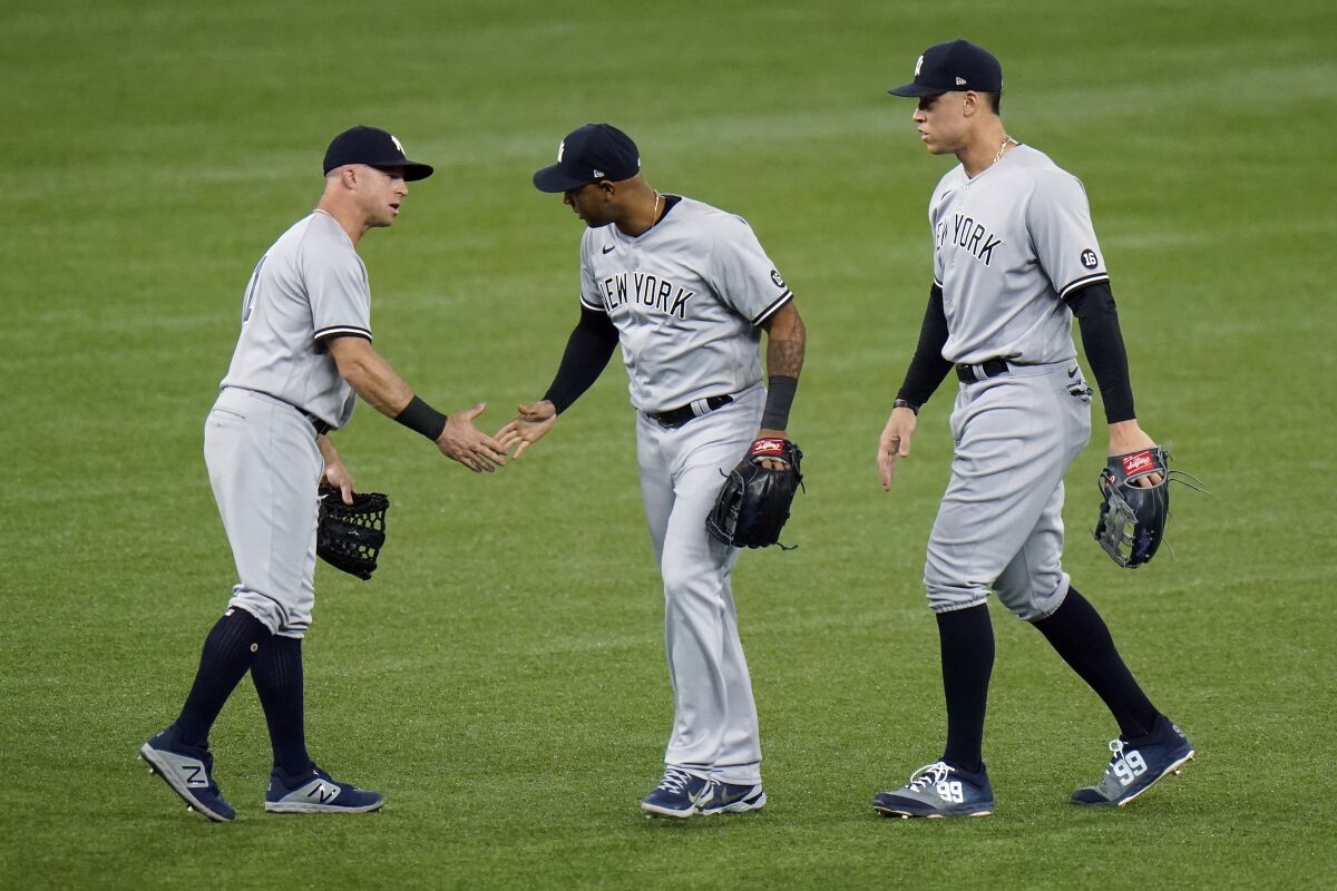 New York Yankees left fielder Brett Gardner, left, center fielder Aaron Hicks, center, and right fielder Aaron Judge celebrate after the team defeated the Tampa Bay Rays during a baseball game Wednesday, May 12, 2021, in St. Petersburg, Fla. (AP Photo/Chris O'Meara)