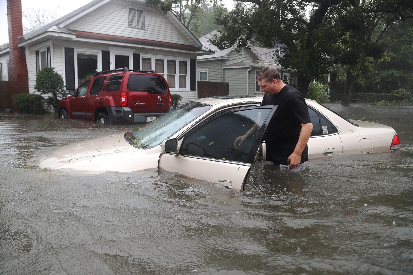 Rob Birch checks on his car floating out of the driveway as Hurricane Matthew passes through St. Augustine, Fla.