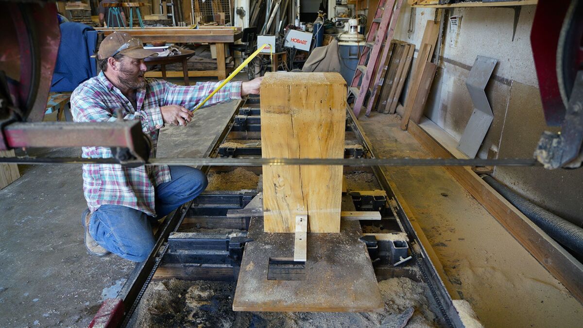 Salvatore Devito works on trimming a large block of wood that will eventually become an Urban Timber bar stool.