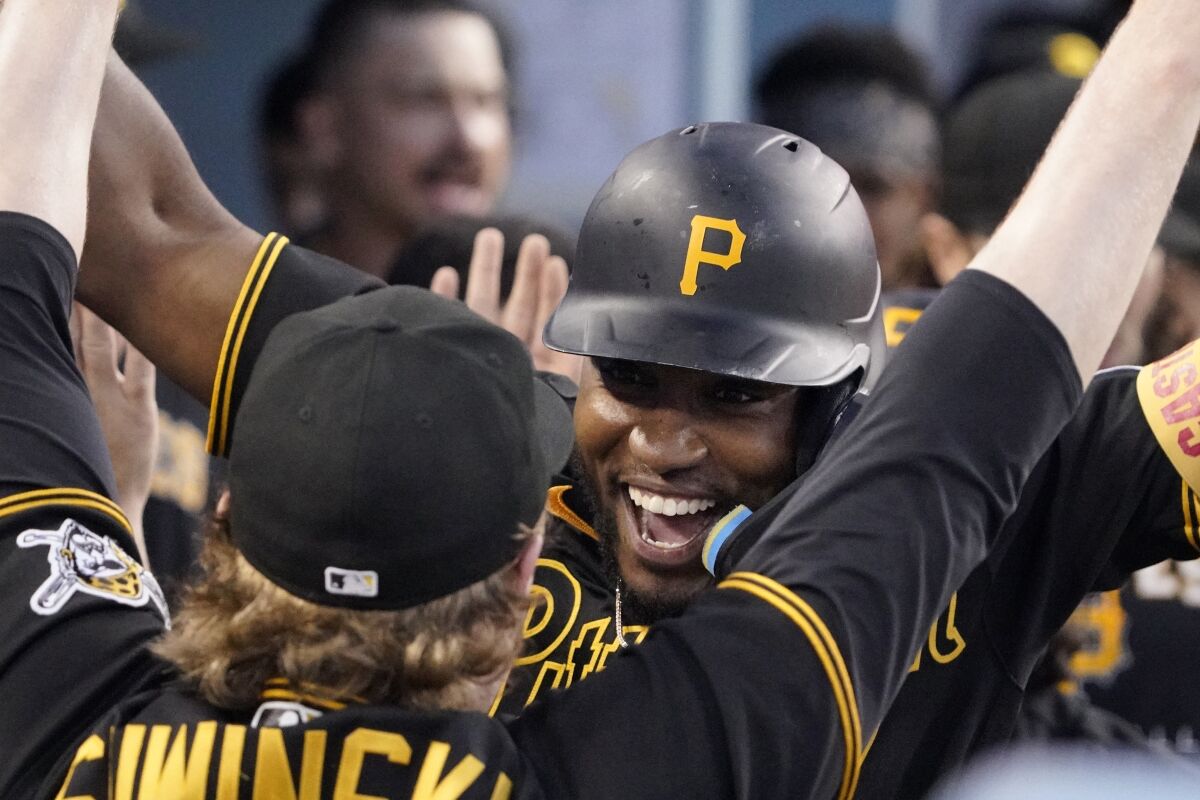 Pittsburgh Pirates' Rodolfo Castro, right, is congratulated by teammate Jack Suwinski in the dugout after hitting a two-run home run during the eighth inning of a baseball game against the Los Angeles Dodgers Wednesday, June 1, 2022, in Los Angeles. (AP Photo/Mark J. Terrill)